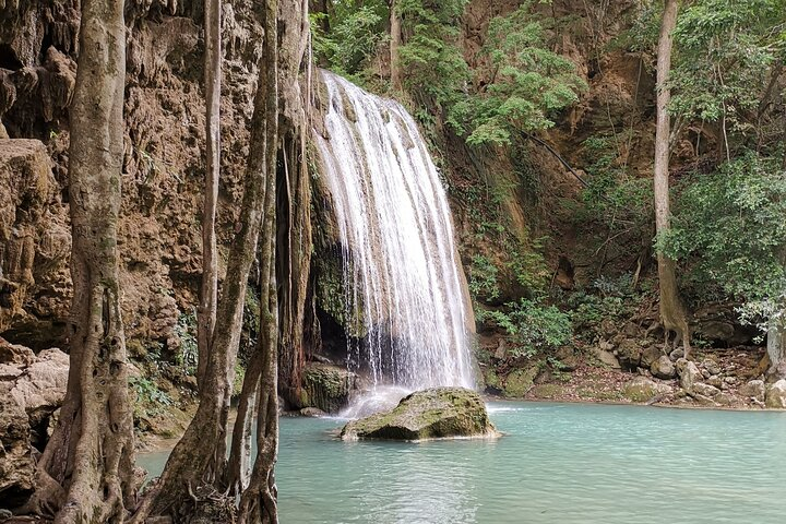 Experience the serene beauty of Erawan Waterfall where crystal-clear waters cascade into tranquil pools inviting travelers to relax and immerse themselves in nature's charm.