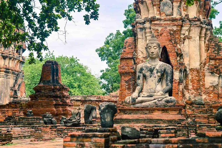 Explore the ancient charm of Ayutthaya's historic temples where serene statues and weathered ruins narrate tales of a bygone era perfect for travelers seeking authentic cultural experiences.