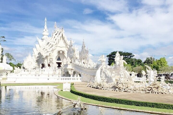 Experience the stunning architecture of Chiang Rai's White Temple perfectly reflecting in serene waters showcasing Thailand’s unique artistry and inviting exploration on this unforgettable journey from Bangkok.