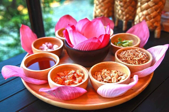 Immerse in the essence of Thai culture with a delightful spread of local flavors showcased amidst the beauty of red lotus petals. A feast for the senses awaits.