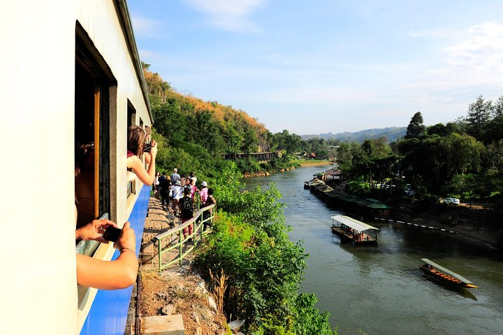 Experience the stunning views along the River Kwai as the train winds through lush landscapes offering glimpses of serene waters and rich history at every turn.