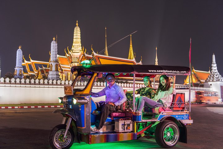 Cruise through Bangkok's illuminated streets in a Tuk Tuk savoring Michelin Guide street food while capturing memories against the backdrop of historic landmarks. A unique night adventure awaits travelers.