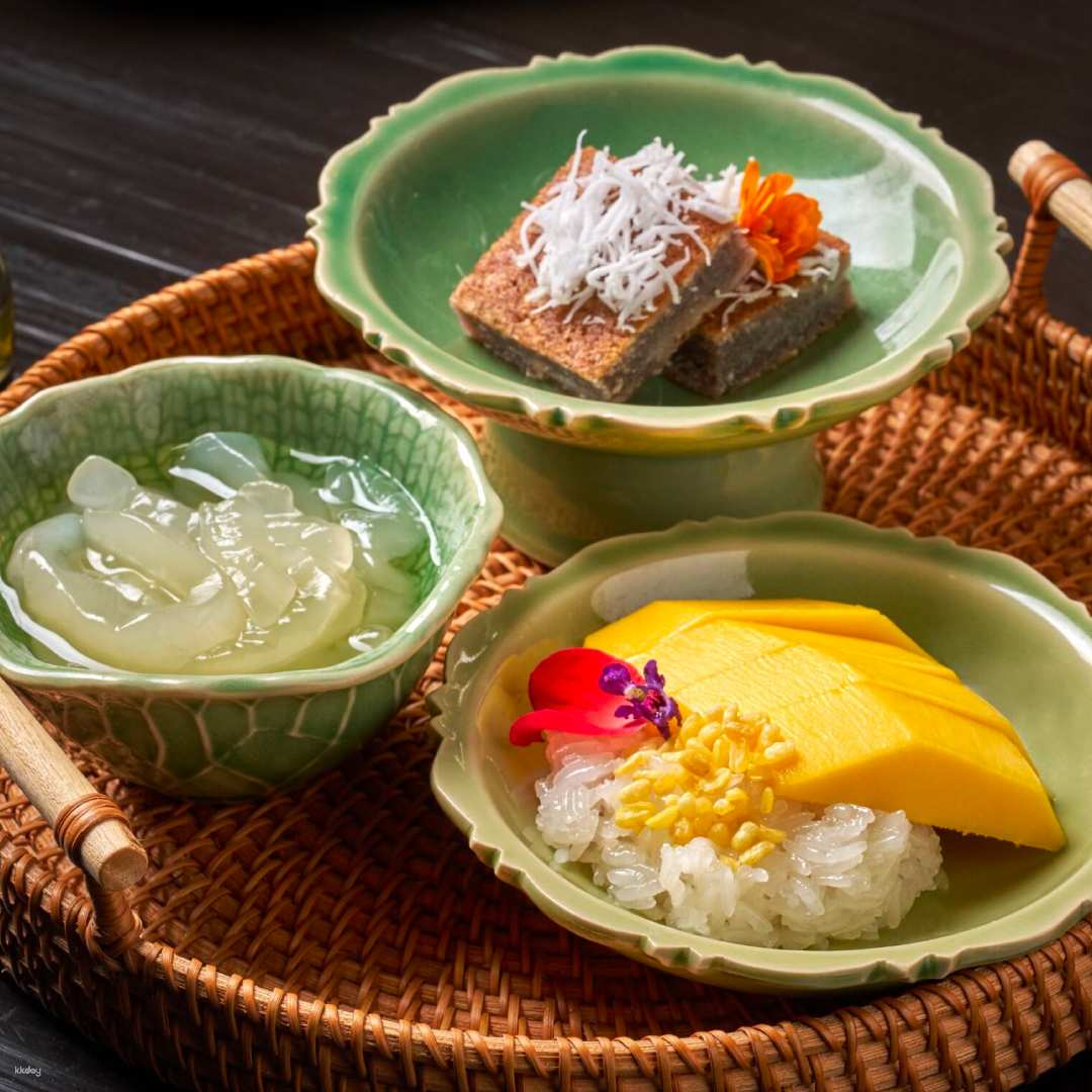 Indulge in a delightful afternoon tea experience overlooking the Erawan Shrine featuring exquisite Thai and European treats paired with refreshing iced teas in a serene setting.