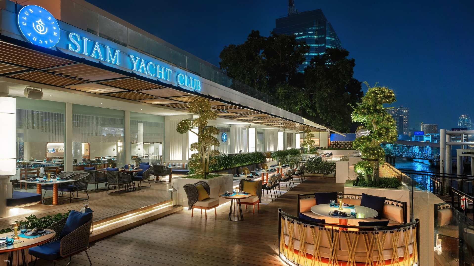 Sip drinks with friends while enjoying live music delicious fusion cuisine and stunning river views at Siam Yacht Club a perfect spot to unwind in Bangkok.