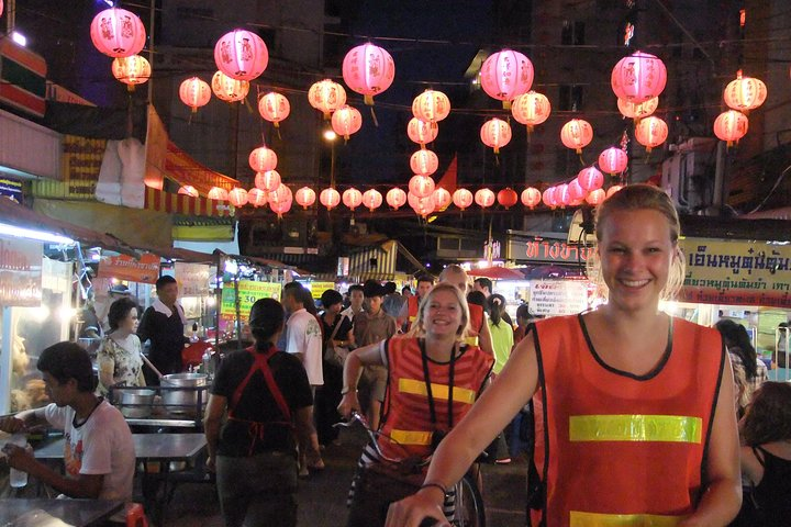 Experience the charm of Bangkok's night markets illuminated by lanterns and filled with local flavors creating a unique biking adventure away from the daytime hustle.