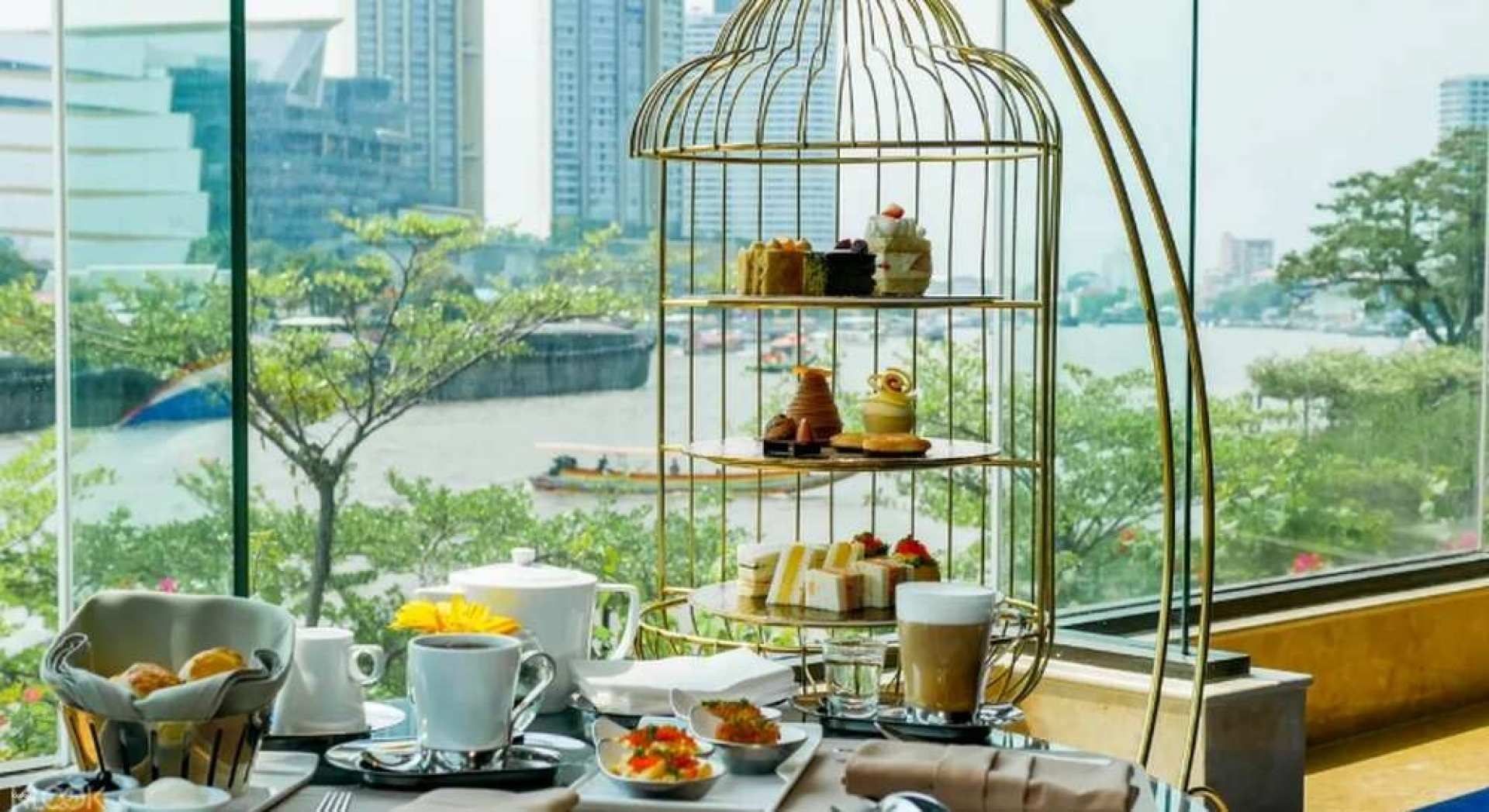 Savor delightful afternoon tea with stunning views of the river alongside the city's skyline while enjoying serene moments at the Lobby Lounge of Shangri-La Hotel Bangkok.