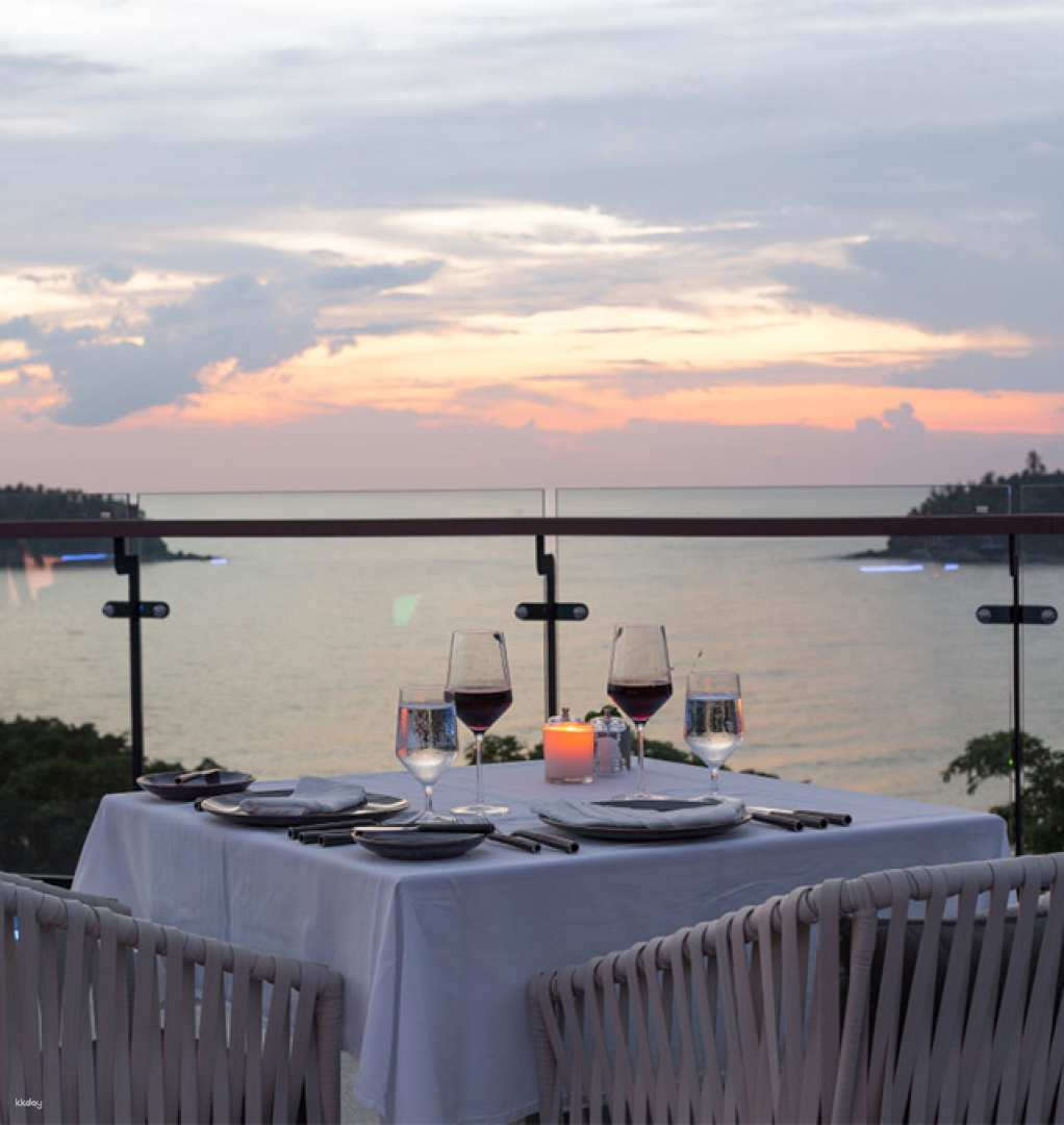 Savor a delightful dinner while watching the sunset over the Andaman Sea with diverse menu options that invite you to explore a world of flavors. The serene skyline reflects on the water’s surface.