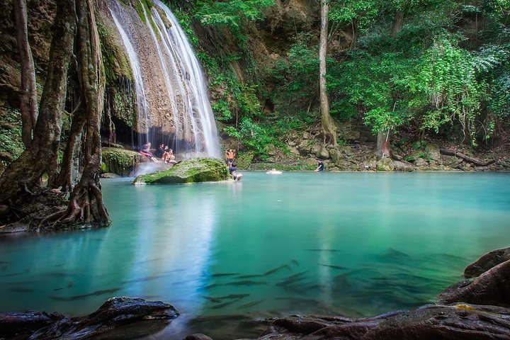 Immerse yourself in the serene beauty of Erawan Falls where cascading waters meet lush greenery creating an idyllic setting for relaxation and exploration in nature's embrace.