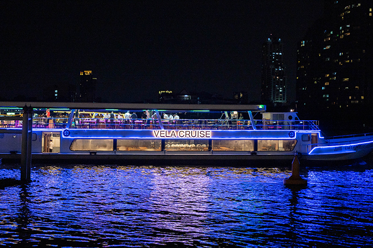 Experience a night of indulgence on the Chao Phraya River savoring delicious cuisine while enjoying stunning views of Bangkok's illuminated landmarks and live entertainment aboard the VELA Cruise.