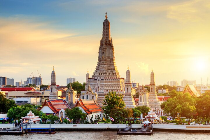 Experience the stunning architecture of Wat Arun as you walk along the river soaking in breathtaking views and rich history in Bangkok's iconic Temple of Dawn.