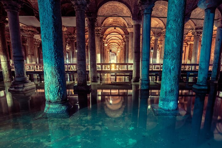 Immerse in the serene beauty of ancient architecture strolling along wooden platforms while marveling at the stunning medusa-head column bases reflecting in tranquil waters. A photographer's dream awaits!