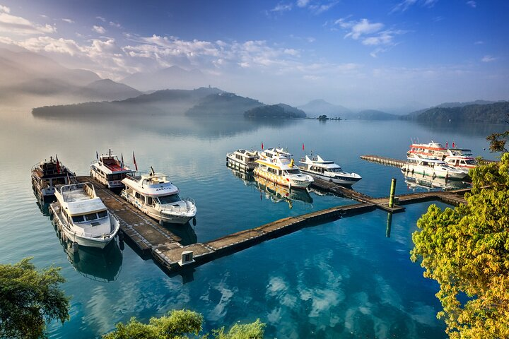 Experience the serene beauty of Sun Moon Lake where calm waters meet stunning mountain views offering a perfect backdrop for exploration by yacht bike or hike along scenic trails.