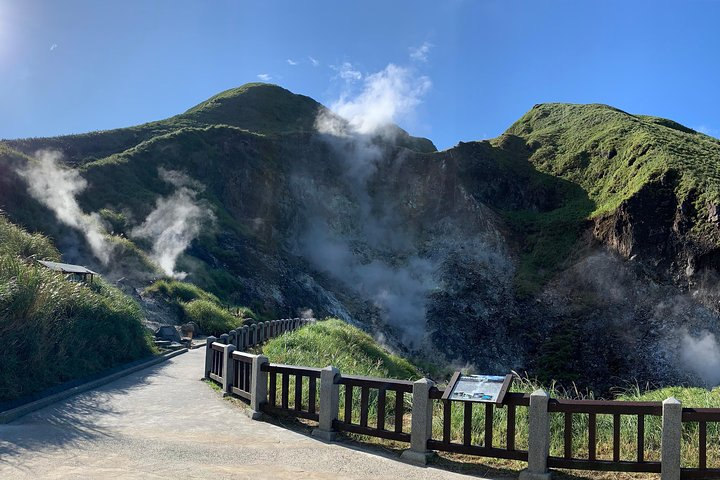 Explore the stunning volcanic landscape of Yangmingshan National Park where steam rises from the earth creating a unique backdrop for your hiking adventure through lush greenery and scenic trails.