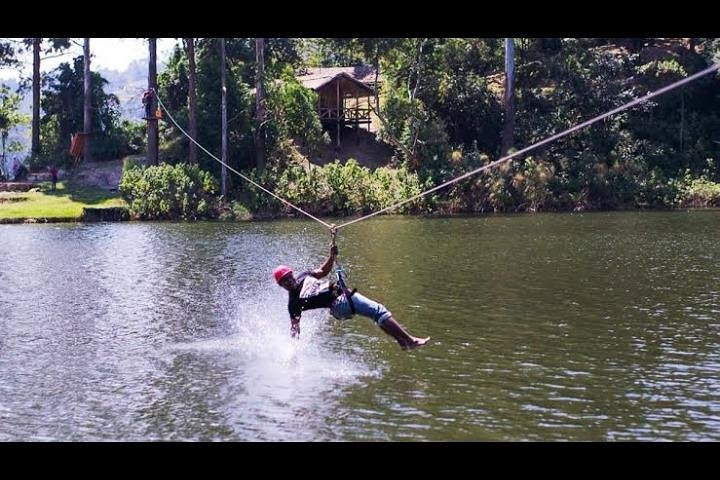 A guest enjoying zip lining over lake buyonyi