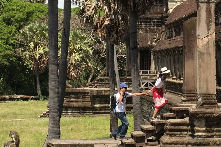 Explore ancient wonders while ascending the majestic steps of Angkor Wat surrounded by lush greenery and a sense of history perfect for unforgettable travel memories.
