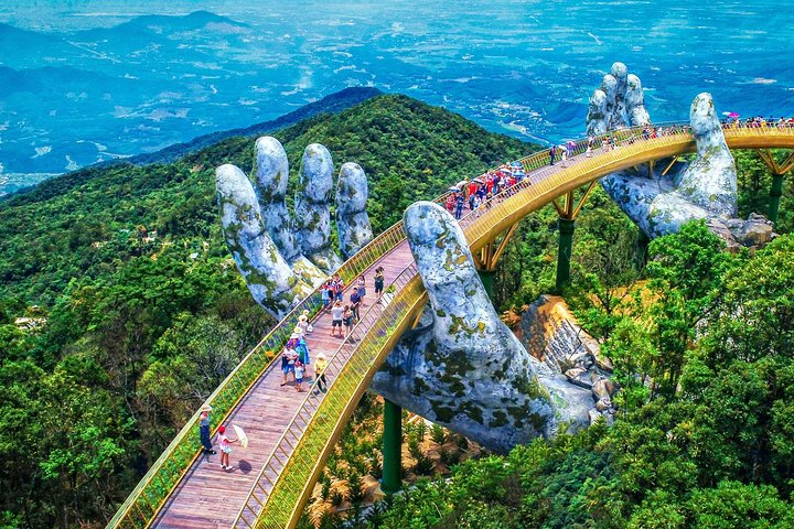 Experience the stunning Golden Bridge held by majestic stone hands surrounded by lush greenery perfect for capturing unforgettable moments and exploring unique landscapes in Ba Na Hills.