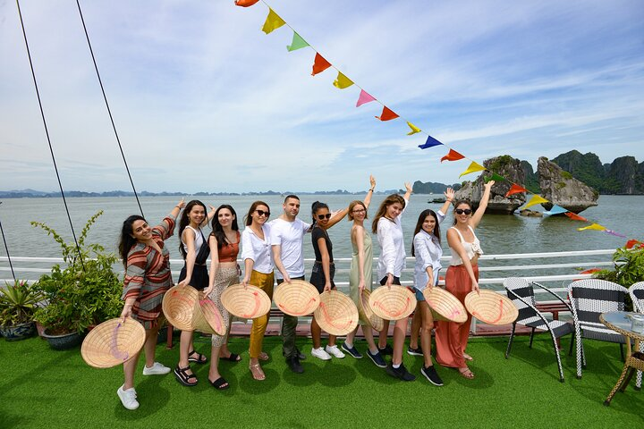 Experience the joy of Halong Bay with friendly faces traditional hats and stunning views. A perfect blend of relaxation and adventure awaits creating unforgettable memories on the water.