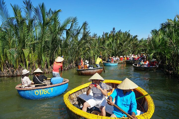 Explore the serene waterways of Cam Thanh Coconut Village where colorful boats glide through lush coconut groves offering an authentic glimpse into Hoi An's natural beauty and local traditions.