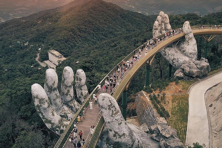 Experience the stunning Golden Hand Bridge in Ba Na Hills where giant hands cradle a breathtaking walkway amidst lush landscapes and picturesque views blending European charm with Vietnamese heritage.