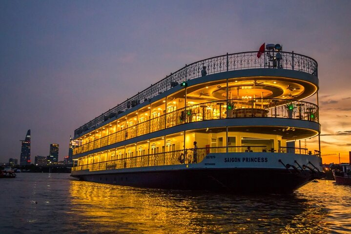 Experience a delightful evening on the Saigon Princess cruise savoring exquisite cuisine while sailing past the illuminated skyline of Ho Chi Minh City accompanied by live music.
