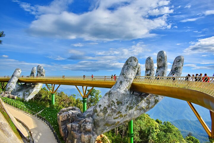 Experience breathtaking views as you stroll along the iconic Golden Bridge framed by stunning mountain landscapes and lush greenery perfect for an unforgettable journey through Vietnam's natural beauty.
