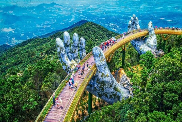 Experience the stunning Golden Bridge a marvel of architecture cradled by giant stone hands surrounded by the lush greenery of Ba Na Hills inviting exploration and wonder.