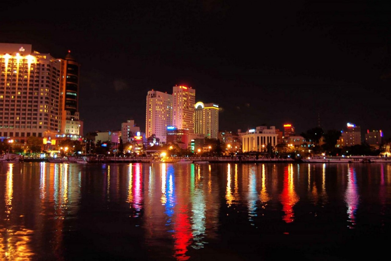 Experience the mesmerizing glow of Ho Chi Minh City's skyline while cruising the Saigon River savoring a delectable Vietnamese dinner as the city's landmarks shimmer in the night.
